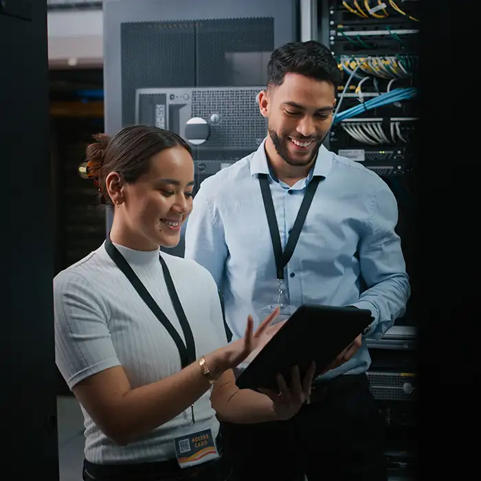 man and woman working in data center looking at tablet