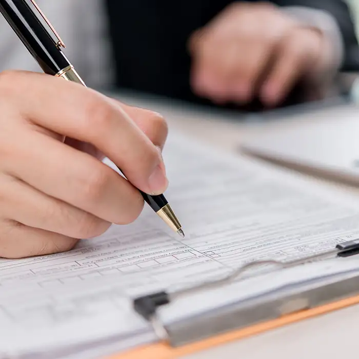 closeup of person using pen on document